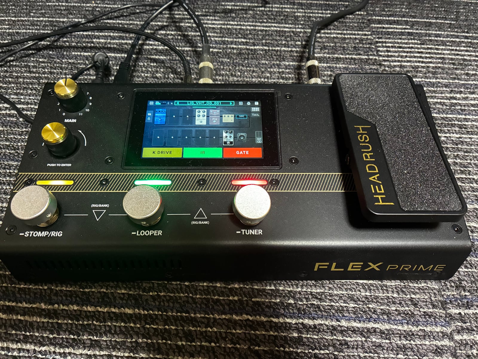 HeadRush Flex Prime本体の接写。画面にはRigのブロック配置が表示され、足元のスイッチにはK DRIVE、IR、GATEが割り当てられている。
